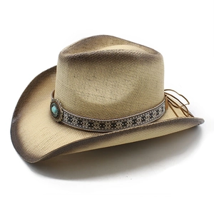 Close-up of woven straw cowboy hat featuring ethnic ribbon and turquoise metal buckle detail
