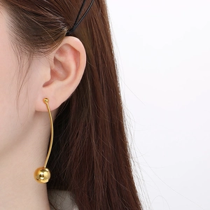 Détail d'une boucle d'oreille longue dorée courbe avec perle de 12mm sur un mannequin
