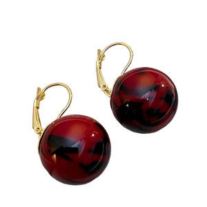 Nahaufnahme der rot-schwarzen Marmor-Resin-Ohrhänger mit vergoldeten Lever-Back-Ohrhaken