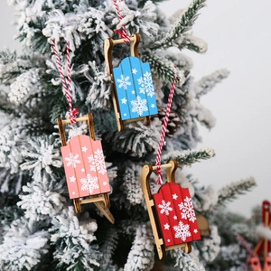 Set of colorful wooden Christmas sleigh ornaments with snowflake prints on tree