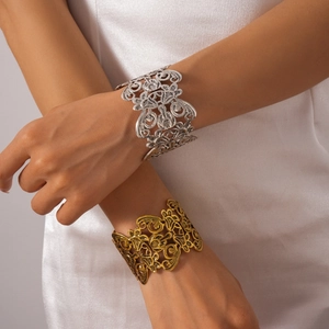 Detail of vintage hollow flower bangle in antique silver and gold metal finishes