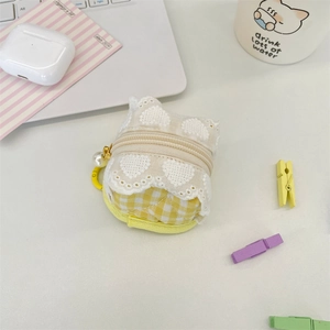 Detail of yellow checkered fabric earphone case with white heart lace embroidery and pearl