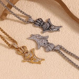 Close-up of hip-hop bird pendants in gold and silver finish with pavé stones