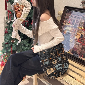 Detail of color-block plush tote bag with blue and orange patterns in warm festive setting