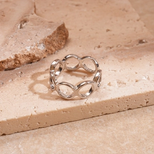 Detailed view of silver geometric hollow ring on a textured natural stone slab background