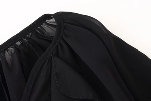 Detail view of the V-neckline and seam stitching on this black long-sleeve shirt