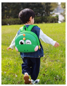 Detail of green 3D dinosaur eggshell backpack showing hard material and yellow zipper