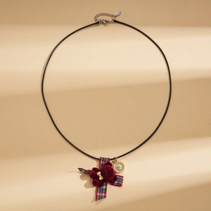 Macro view of flocking red bear pendant with plaid bow and golden heart charm