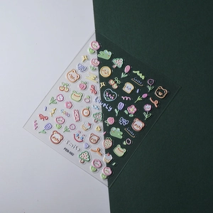 Detail of 3D embossed nail stickers showing cute cartoon frogs and cherry patterns