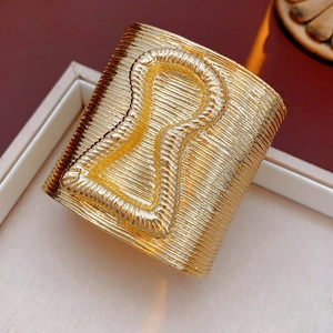 Macro detail of gold vintage cuff bracelet with linear texture in jewelry box