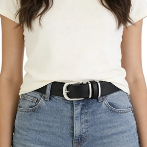Classic black leather belt with silver pin buckle worn on light blue denim jeans