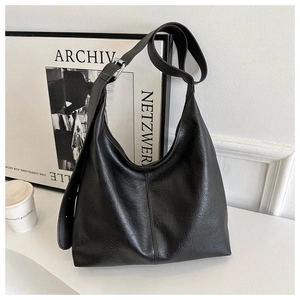 Close-up of black PU leather shoulder bag featuring soft texture and silver hardware details