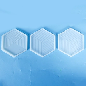 Detailed view of three hexagonal silicone molds with geometric stripe patterns for resin DIY