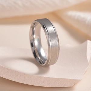 Primo piano dell'anello in acciaio inossidabile satinato opaco su pietra naturale