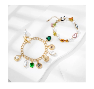 Detail of vintage gold bracelets featuring colorful charms, pearls and OT toggle clasps