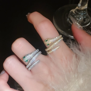 Macro detail of serpent ring with emerald green eyes and sparkling paved zircon setting