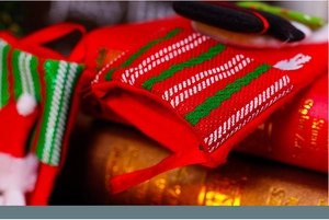 Detail of red Christmas stocking featuring knit stripes, sequins, and hanging loop