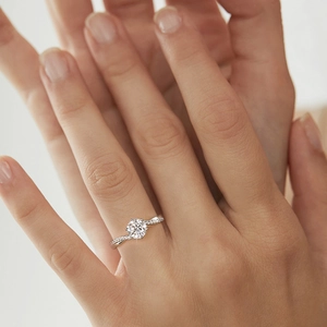 Macro view of 925 silver moissanite ring with a six-prong round cut stone on model hand