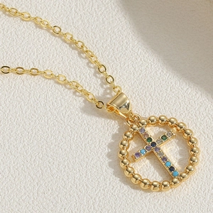 Detailed macro view of 14K gold-plated cross pendant with multicolor zircon stones
