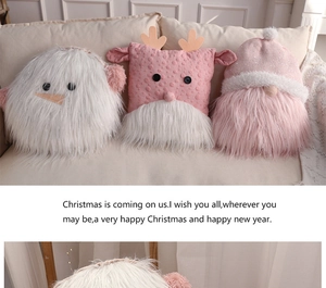 Close-up of plush snowman, deer, and gnome pillows on a white sofa for Christmas decor