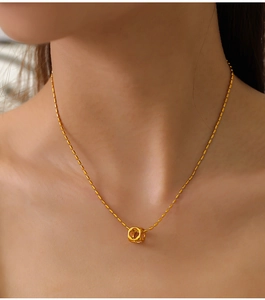 Detail shot of a hollow square pendant on a beaded gold-plated titanium steel necklace