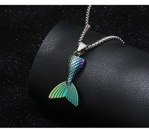 Macro shot of colorful iridescent mermaid tail pendant with detailed scales on silver chain