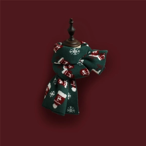 Detail of dark green knit scarf with red and white festive deer and snowflake patterns