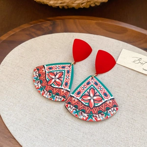 Detail of bohemian fan-shaped earrings with ethnic print and red triangular studs