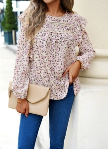 Detail of floral long sleeve blouse featuring pink and purple ruffles with lace trim