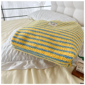 Detailed macro view of yellow and blue striped plush fabric texture with woven label