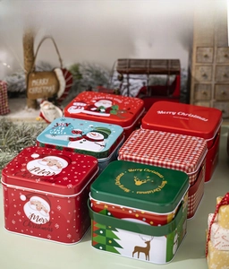 Detailed view of assorted Christmas tin boxes with festive Santa and snowman patterns