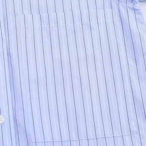 Detail of light blue striped shirt showing chest pocket and fine fabric texture