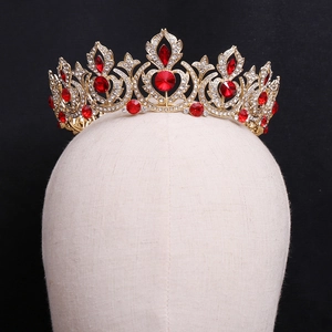 Close-up of a vintage bridal crown with red gemstones and crystals on a mannequin head