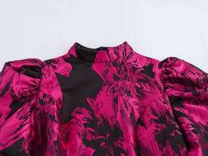 Close-up of elegant satin dress collar with magenta jacquard pattern and puff sleeves