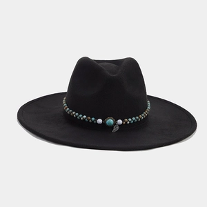 Detail of black fedora hat featuring ethnic beaded band with turquoise stone and leaf charm