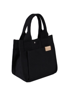 Detail der schwarzen 16oz Canvas-Tasche mit Seitentasche und beige Leder-Akzentetikett