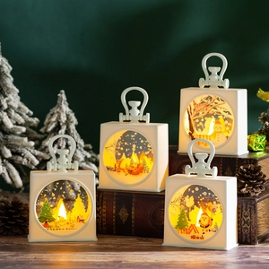 Close-up of portable Christmas LED lanterns with Santa and Snowman on a vintage desk