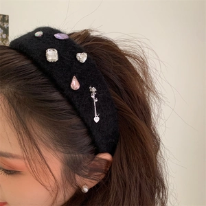 Close-up of plush headband with rhinestone embellishments and silver rose charm