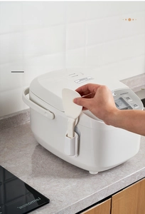 Detail of suction cup rice paddle holder mounted on white electric rice cooker