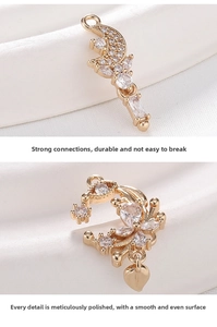 Detailed view of cubic zirconia moon and flower charms on white silk fabric background