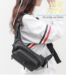 Men's black nylon waist bag with multiple zipper pockets and adjustable strap shown on model