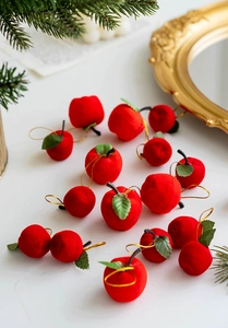 Detailed view of red flocked foam Christmas apples with green leaves on gold mirrors