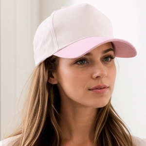 Side view of two-tone cotton baseball cap in beige and pastel pink on a model