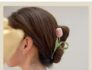 Close-up of a large pink tulip hair claw clip holding an elegant updo hairstyle