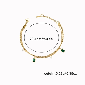 Detail view of gold titanium bracelet with emerald crystals and white pearls