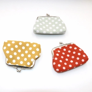 Detailed view of three polka dot canvas coin purses with vintage metal clasp closure