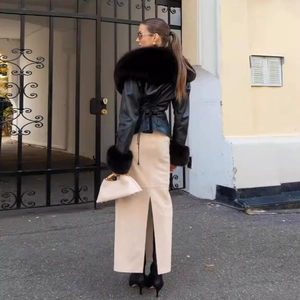 Women's chic black faux leather jacket with fur collar and beige slit skirt outfit