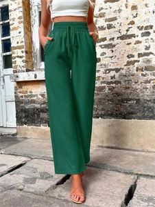 Détail du pantalon large vert foncé avec taille élastique à cordon et boutons décoratifs