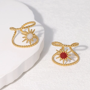 Detail of adjustable gold sunburst rings with colorful enamel and beaded texture