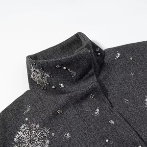 Dettaglio di ricamo con perline argentate e paillettes su collo di giacca in lana